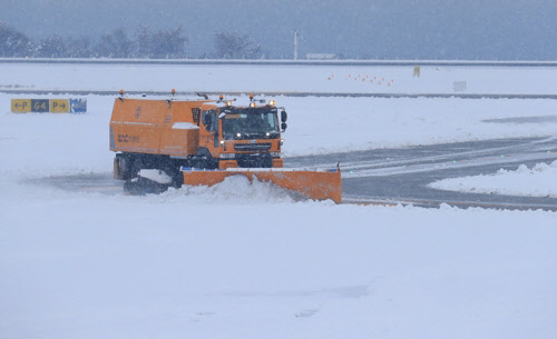 한국공항공사 제설차량이 제주공항 활주로의 눈을 치우고 있다. 연합뉴스